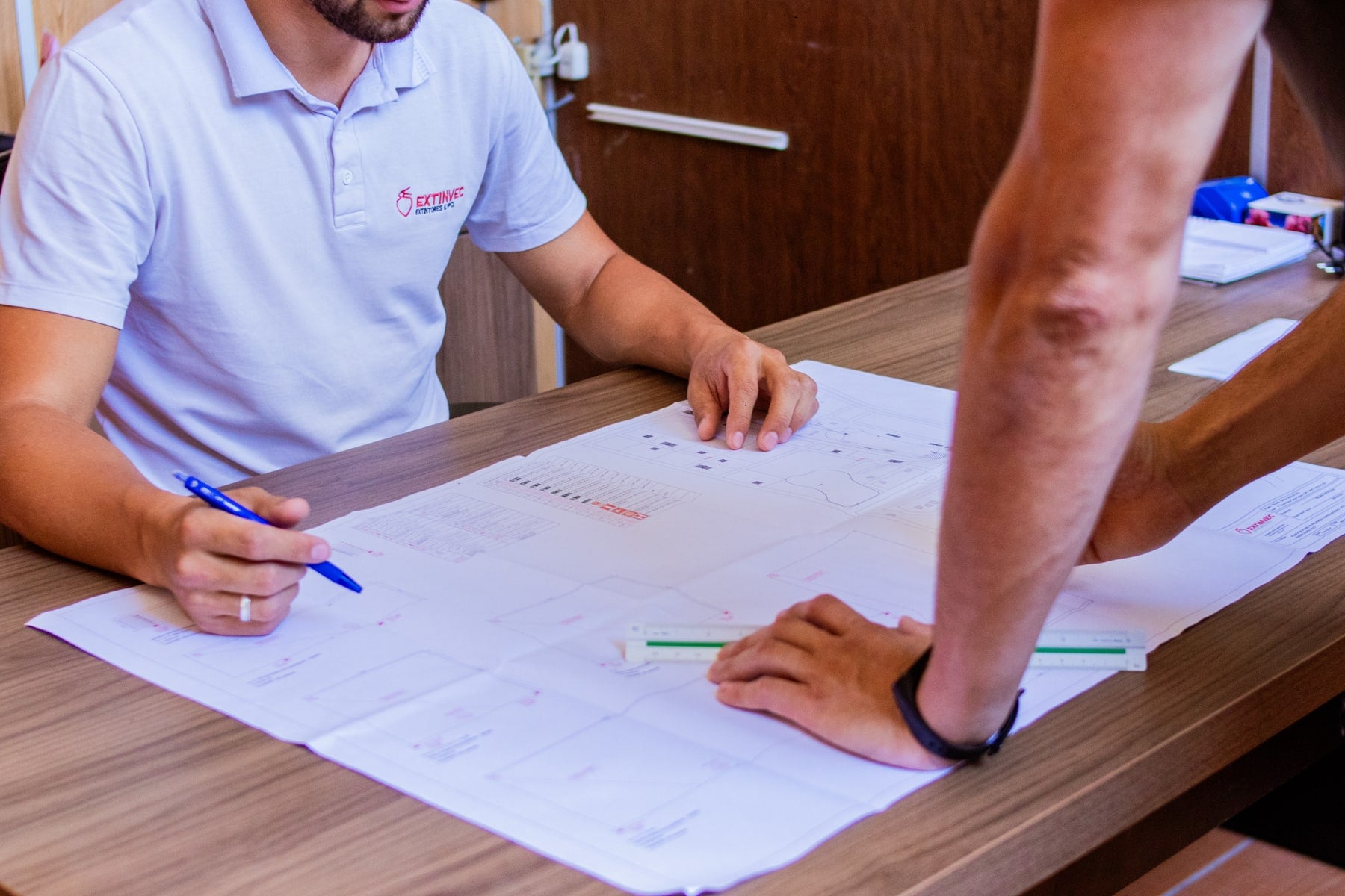 Equipe técnica da Extinvec analisando a planta de um projeto de PPCI